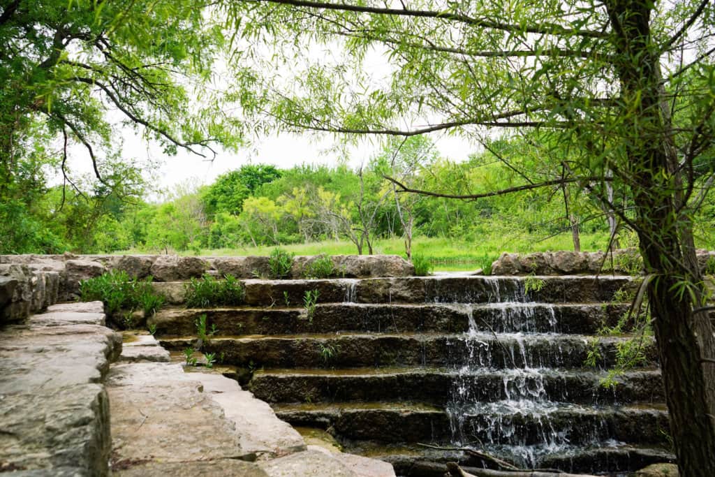 Park area with small waterfall falling down steps