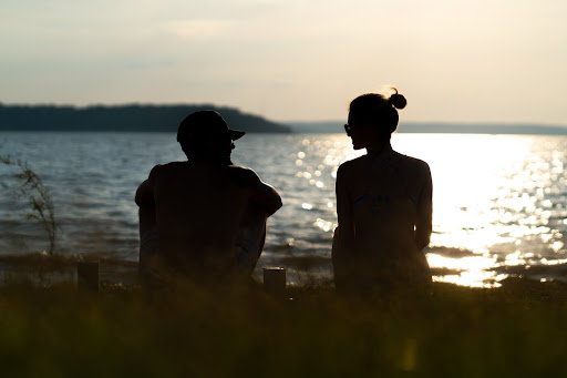 couple sitting in front of a lake 