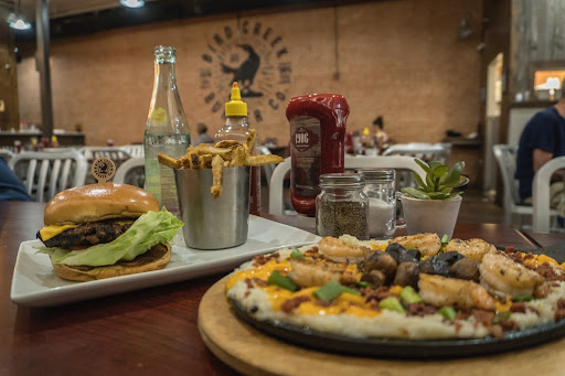pizza and a burger on plates on a table in a restaurant