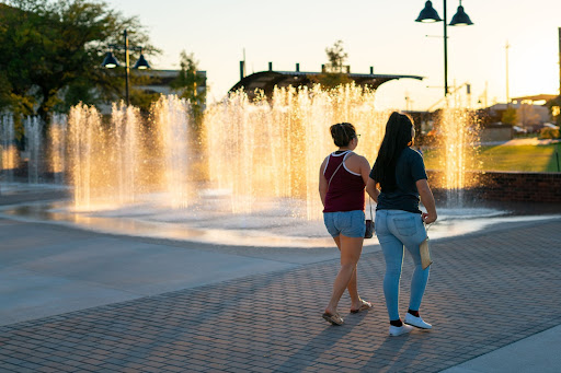 two women walking near a fountain