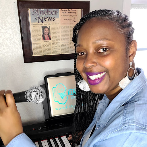 woman smiling in front of a piano holding a microphone